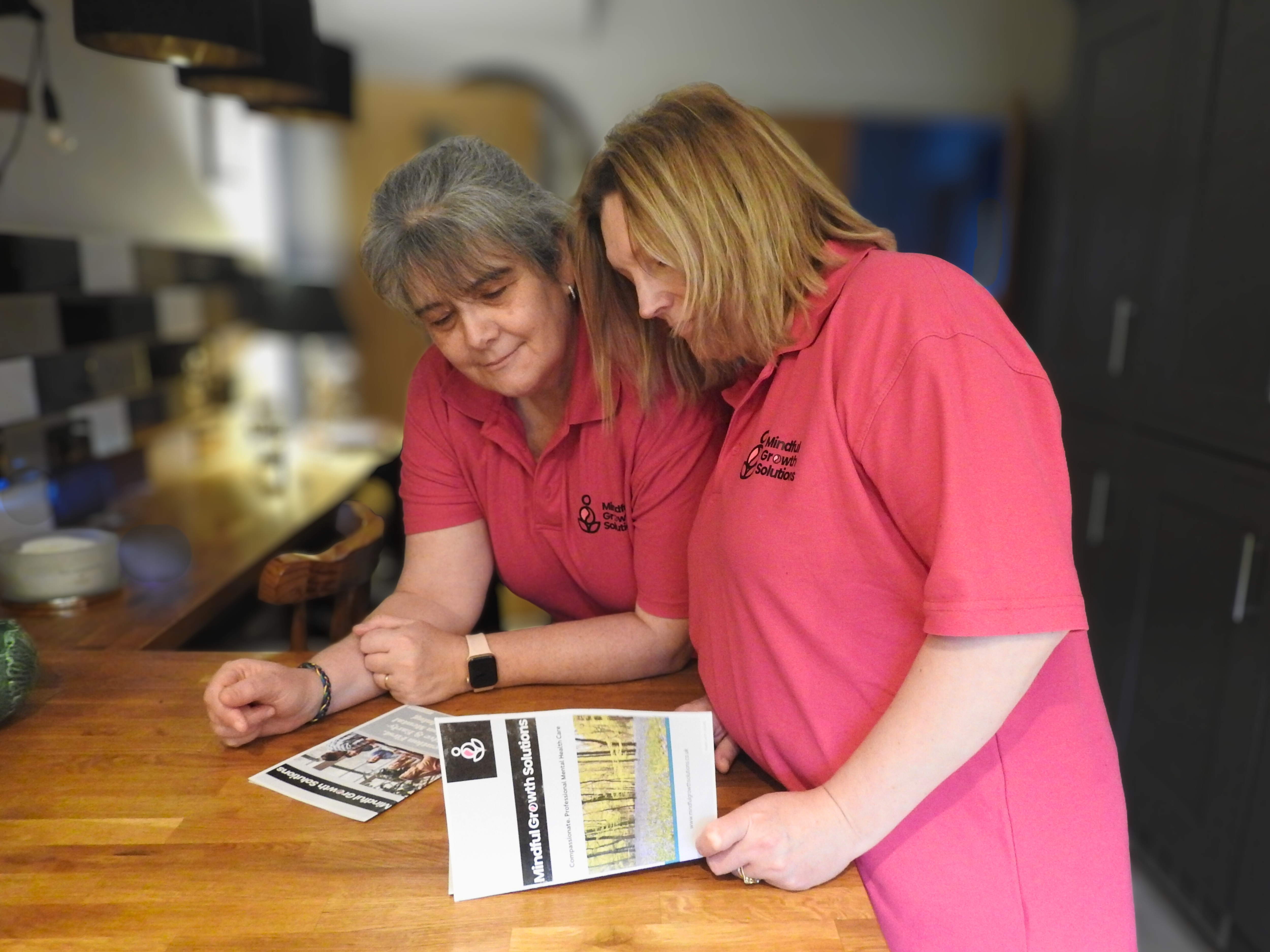 Debbie and Angela looking at the Mindful Growth Solutions Booklet